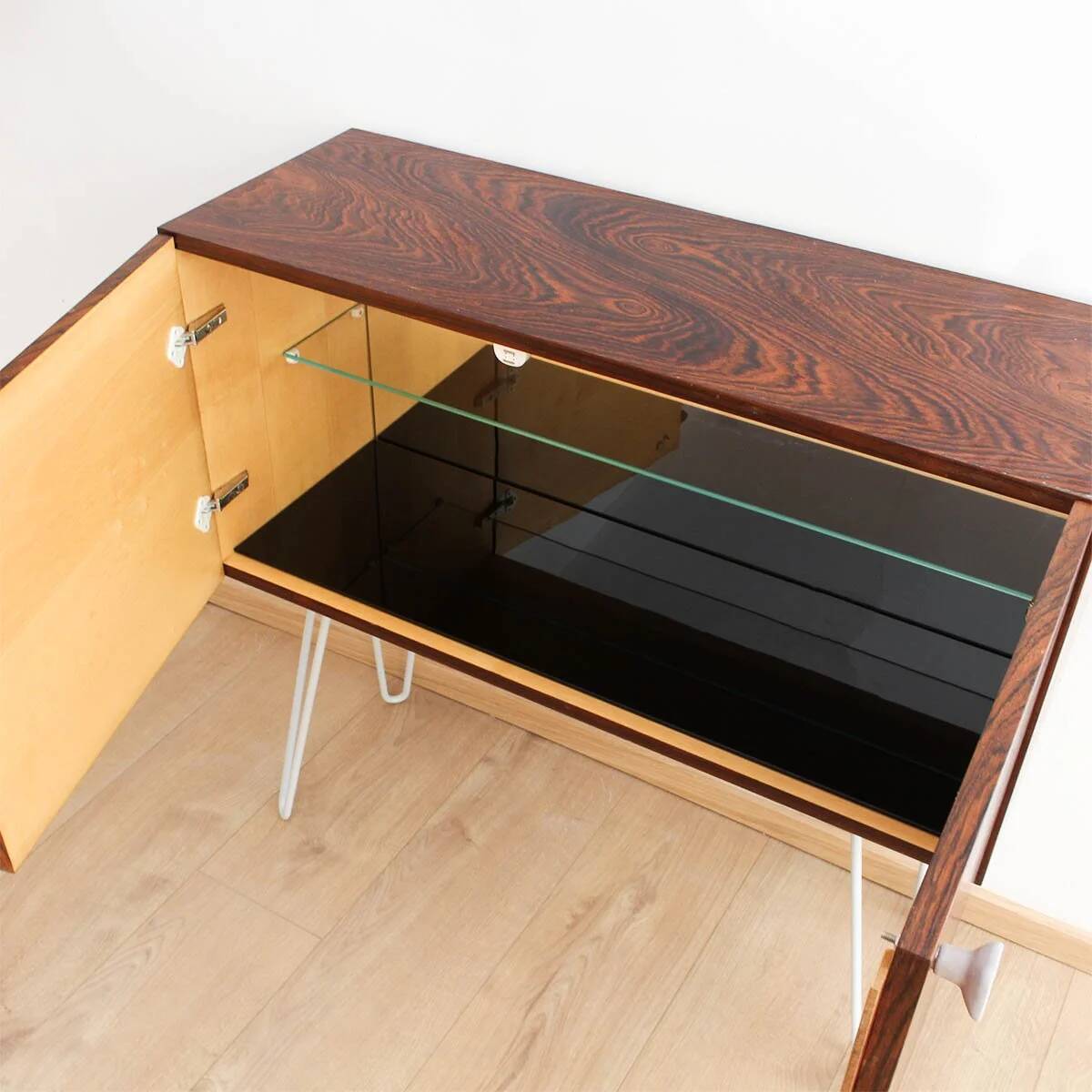 Buffet en palissandre avec des pieds en métal gris clair en forme de épingle.