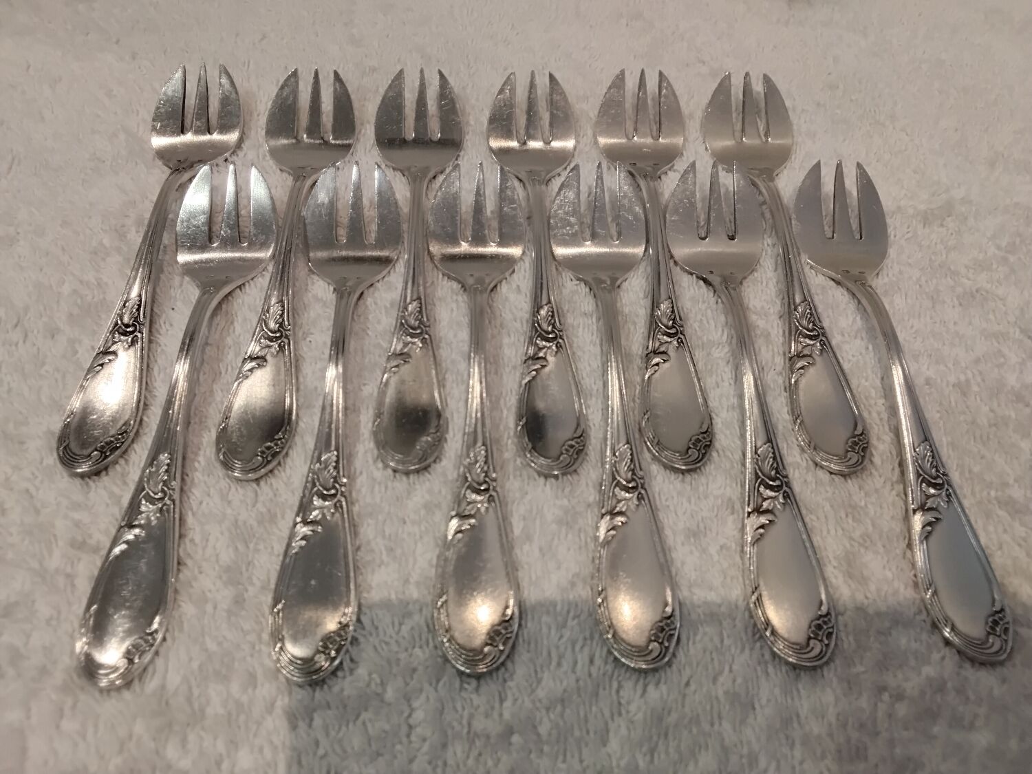 12 silver-plated oyster forks with rocaille ribbon decoration, 13.7 cm