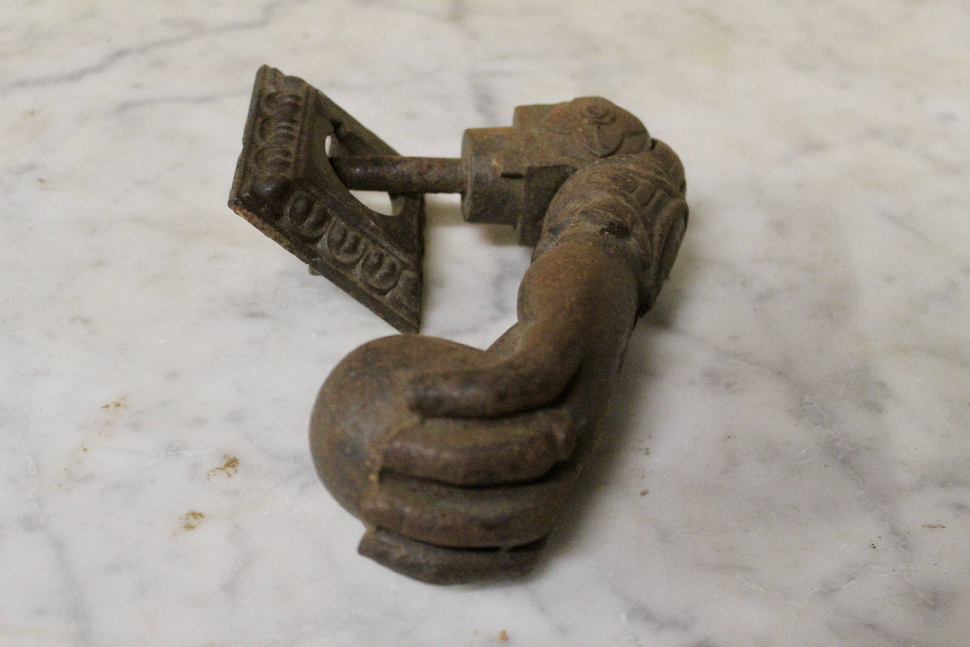 Antique cast iron door knocker in the shape of a 19th century hand