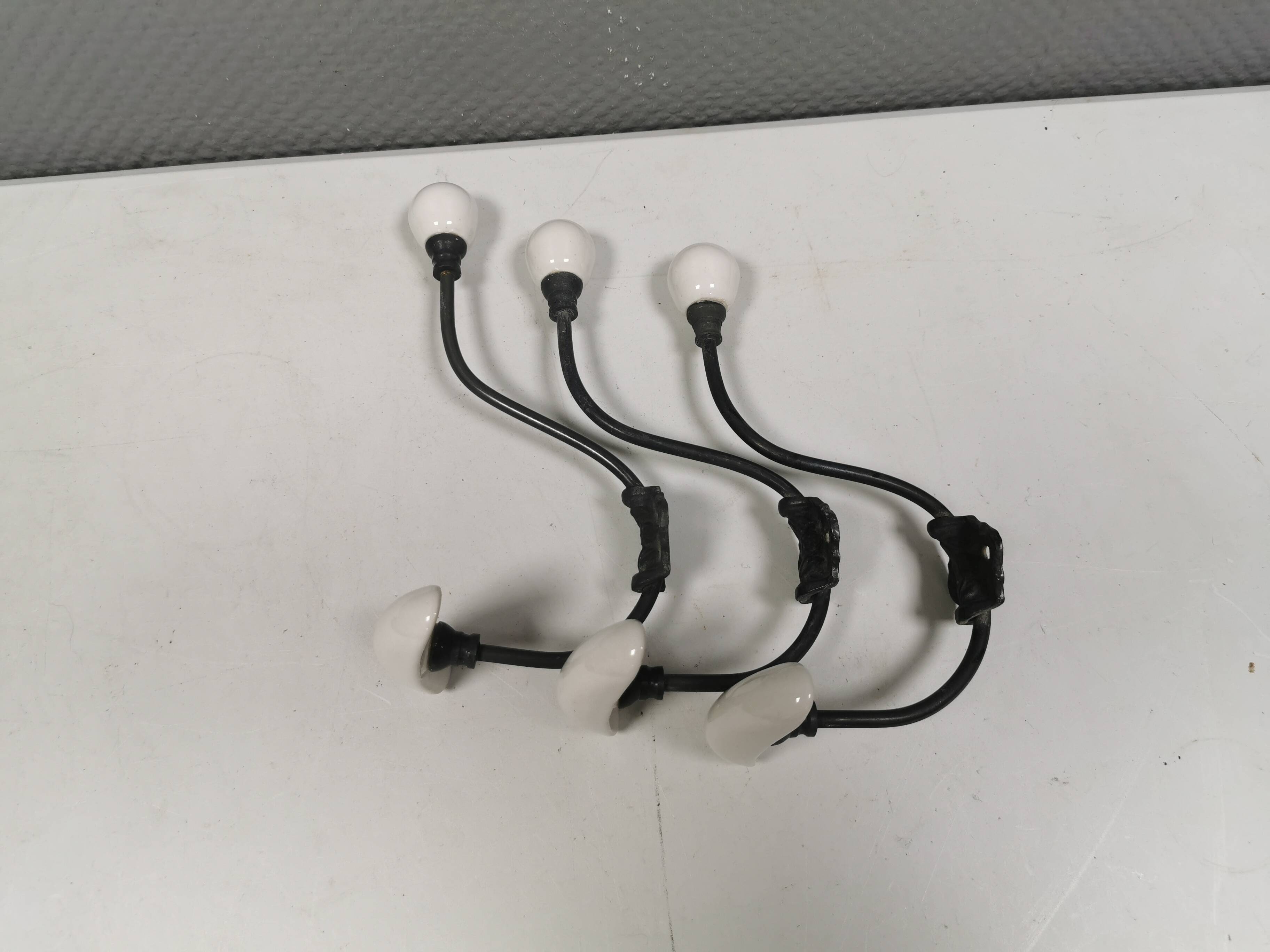 Coat hooks made of galvanized brass and raw white porcelain