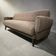 Vintage armchair/sofa/lounge in taupe colour with a stain.