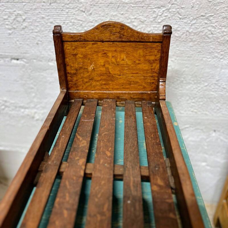 Old doll's bed in varnished wood