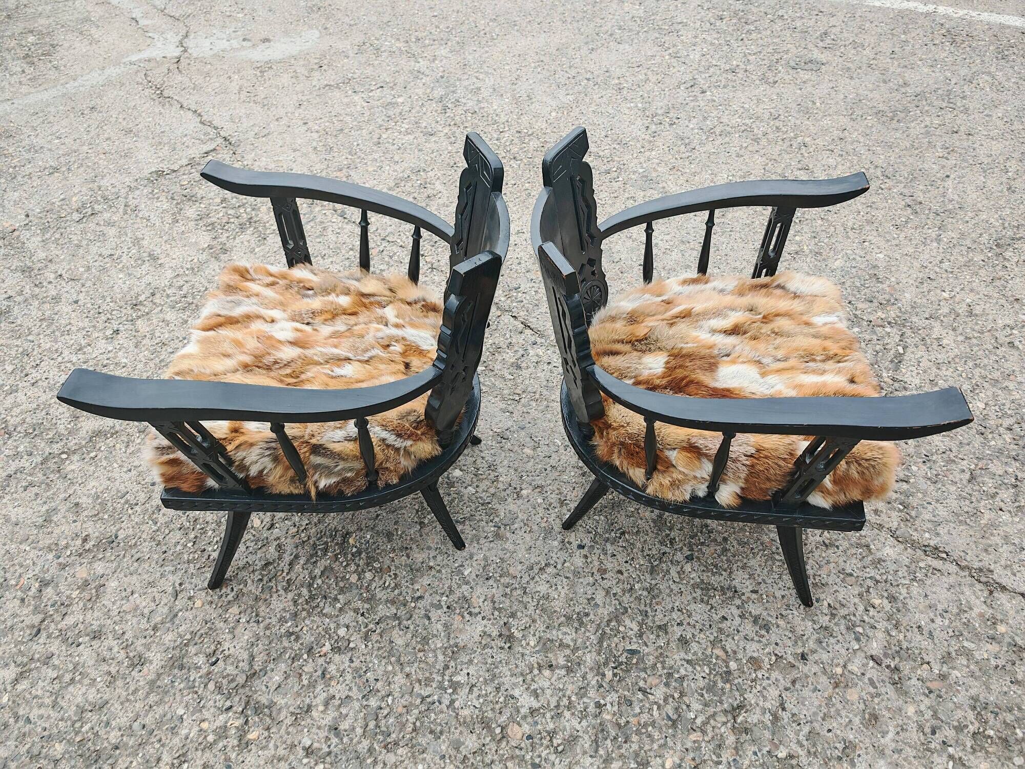 Pair of hand-carved armchairs in black lacquer and fur, 1920s.