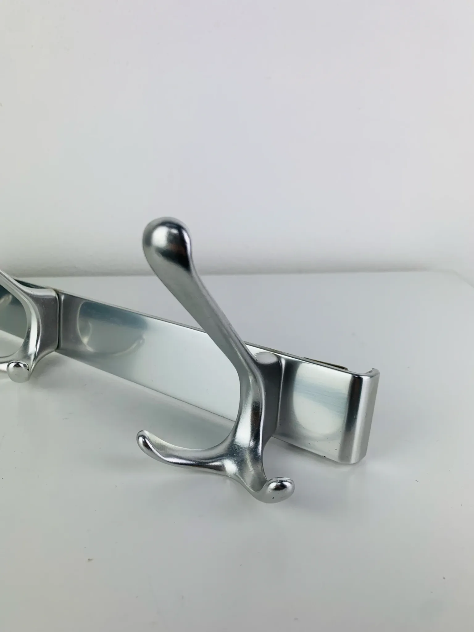 Wall-mounted coat rack, strip of 3 aluminium hooks from the 1960s.