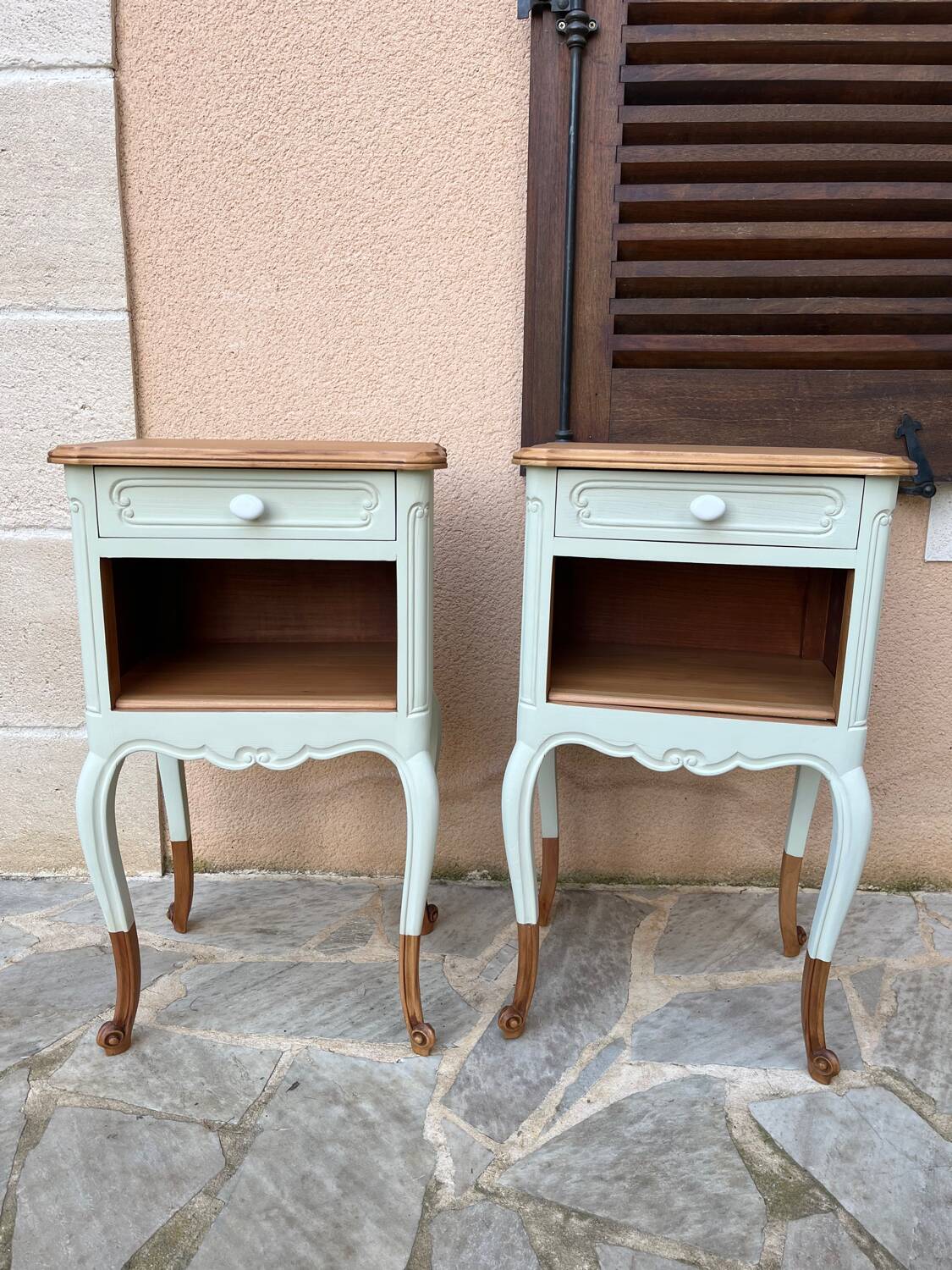 Renovated bedside tables in laurel green and light wood.