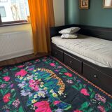 Tapis roumain en laine noire avec un panier de fleurs colorées