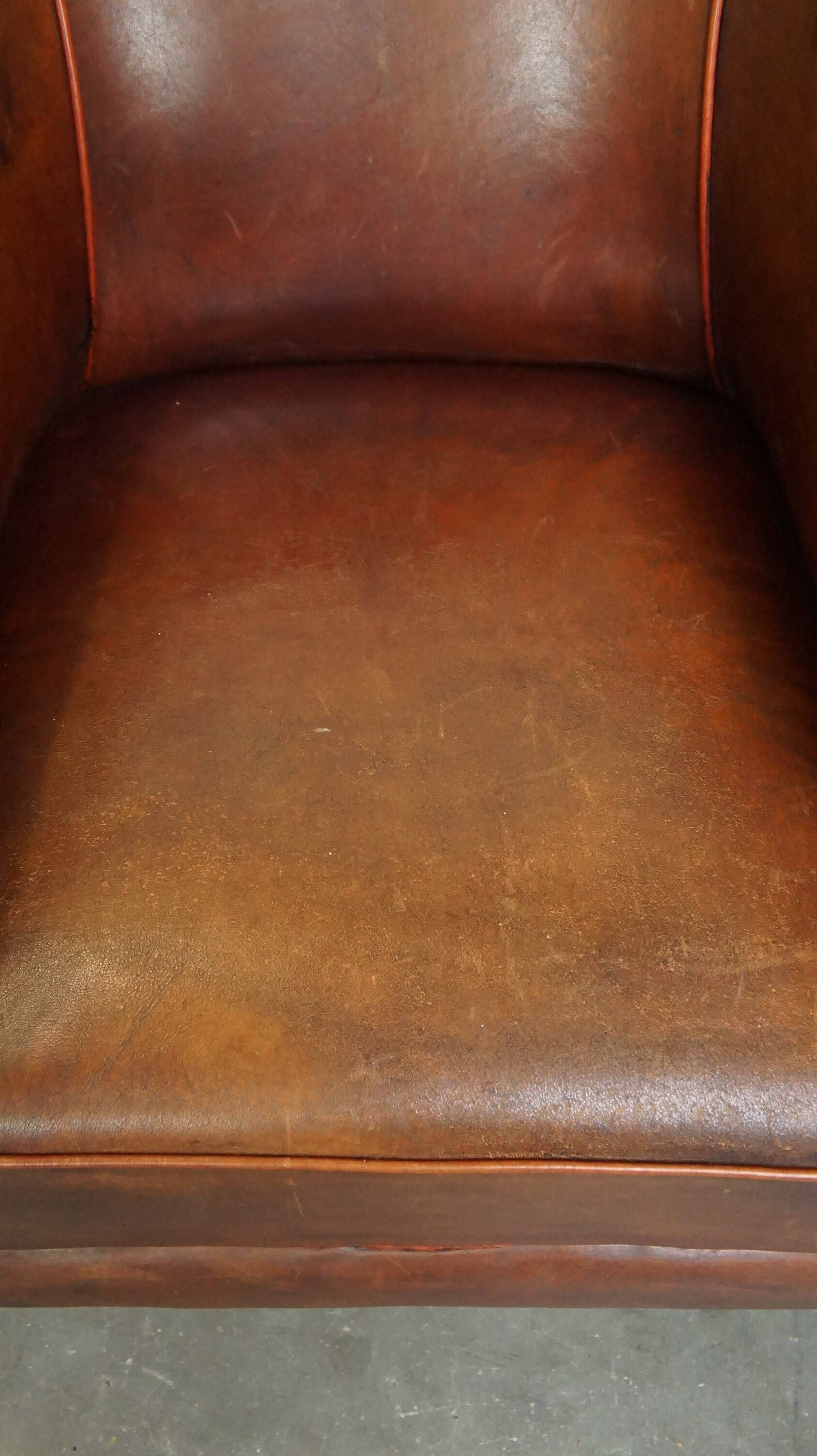 Neat, elegantly finished, cozy sheepskin club armchair with a fixed seat cushion