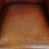 Neat, elegantly finished, cozy sheepskin club armchair with a fixed seat cushion