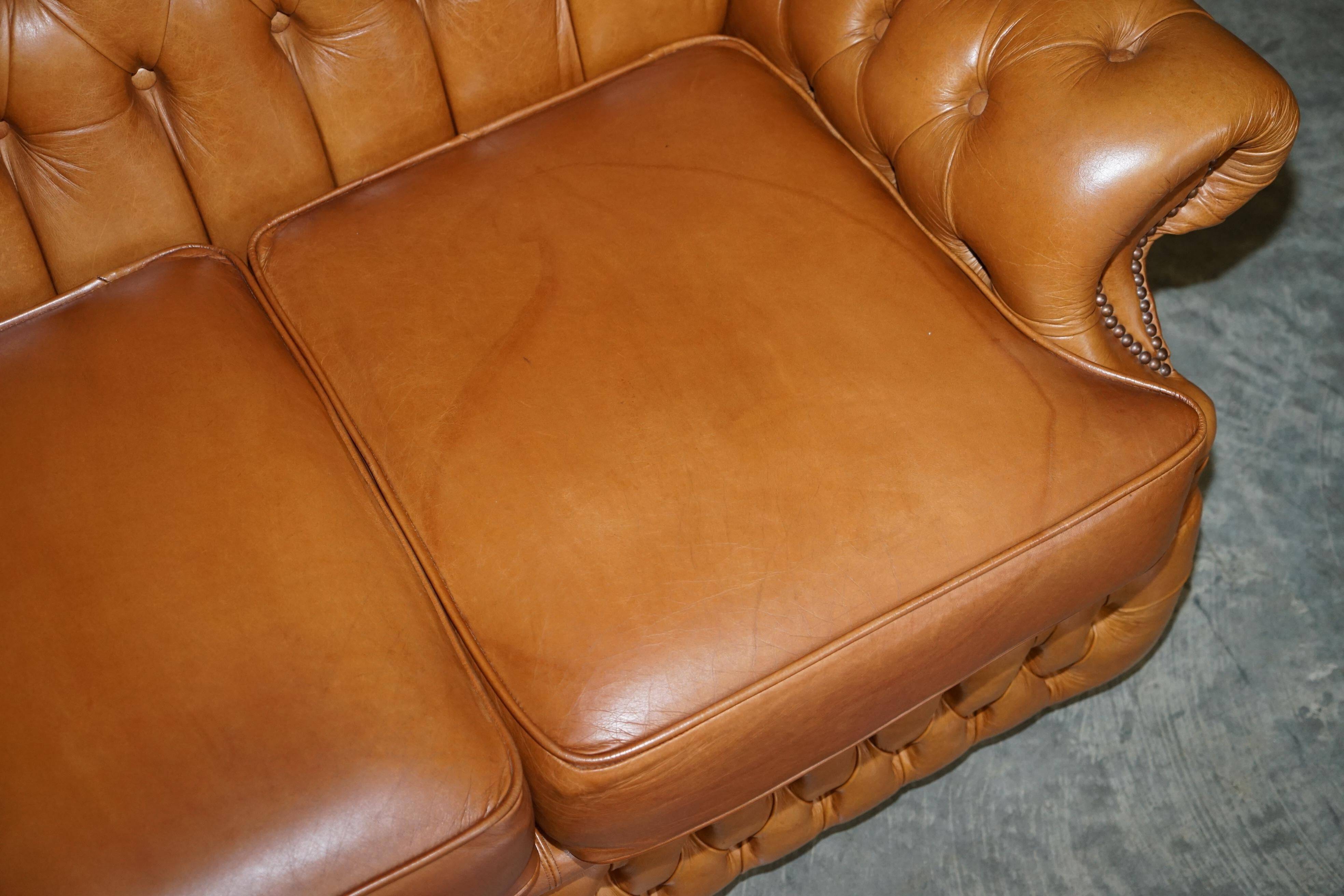Small Chesterfield leather sofa with a high back.