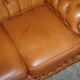 Small Chesterfield leather sofa with a high back.