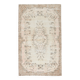 Rare tapis vintage fait main tons rose poudré et beige, motifs floraux