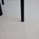 Round dining table in black lacquered metal with a granite top.