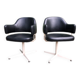 Duo de fauteuils vintage en Skaï noir à piétement métallique.