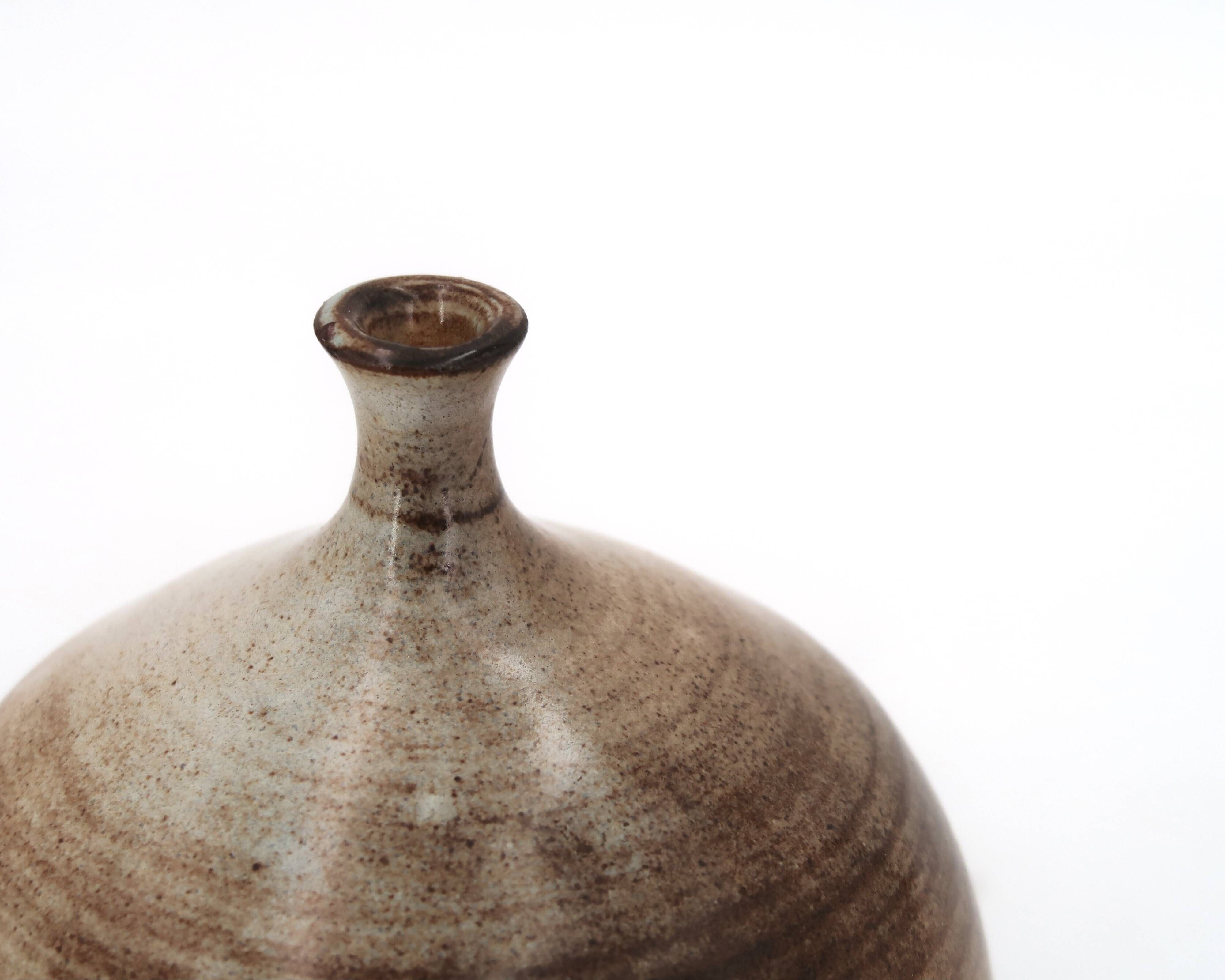 Ovoid vase with a small neck in brown beige ceramic and white drips.