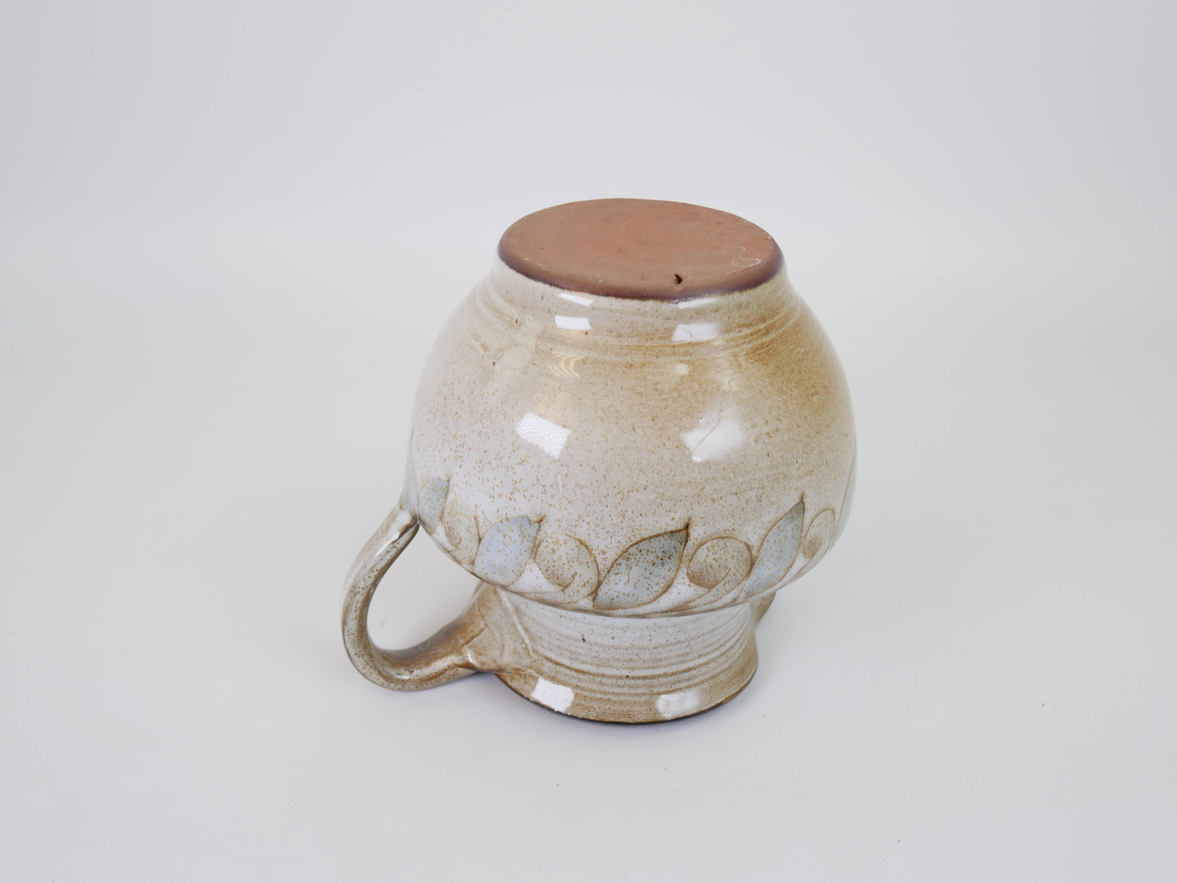 Glazed ceramic jug with plant decoration