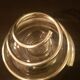 Round glass candle holder with silver-plated metal spiral.