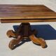 Old walnut table with a central leg.