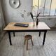 Oak farmhouse table with turned black legs.