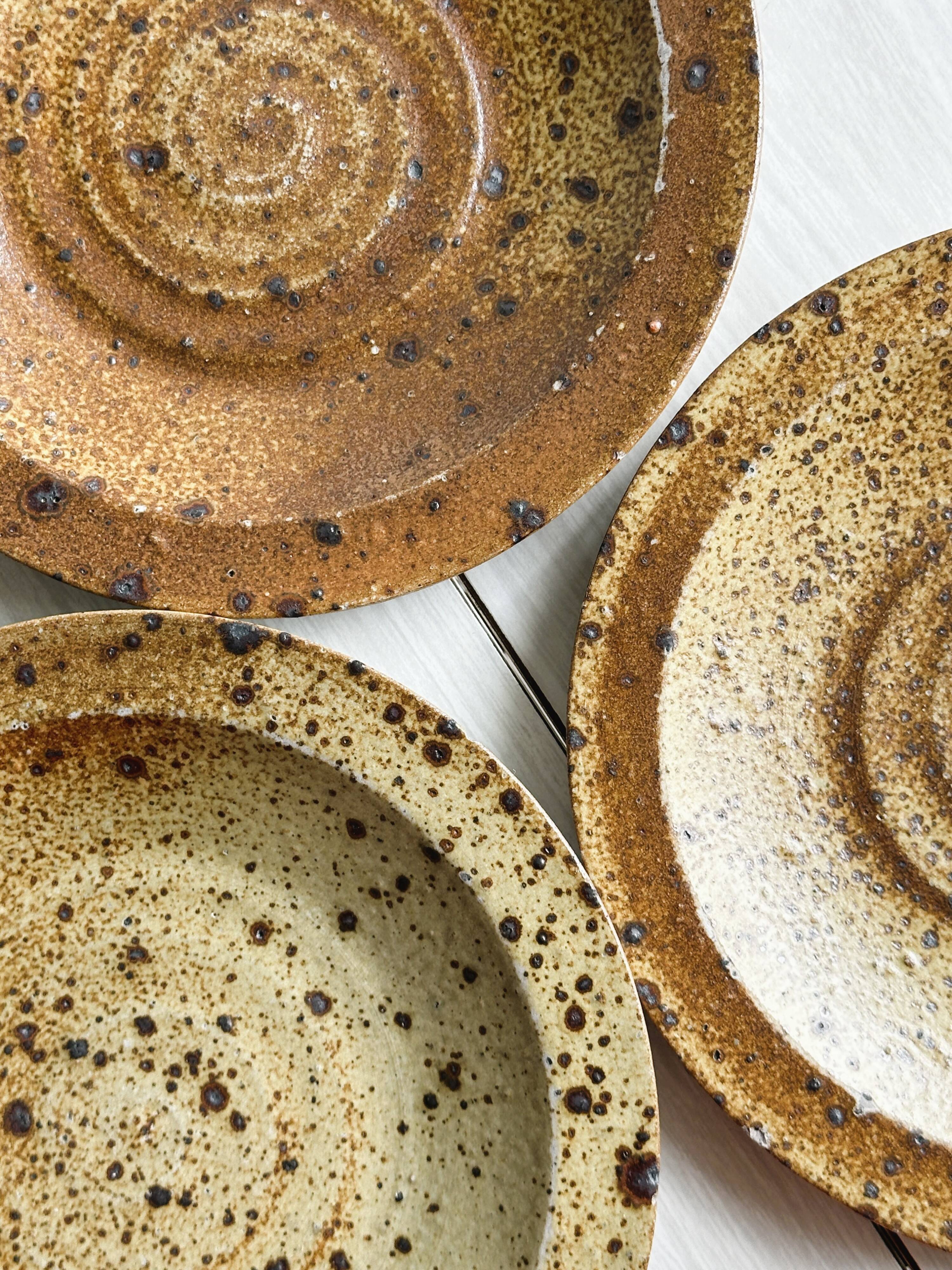 3 assiettes en grès rustique, finition mouchetée marron et beige.