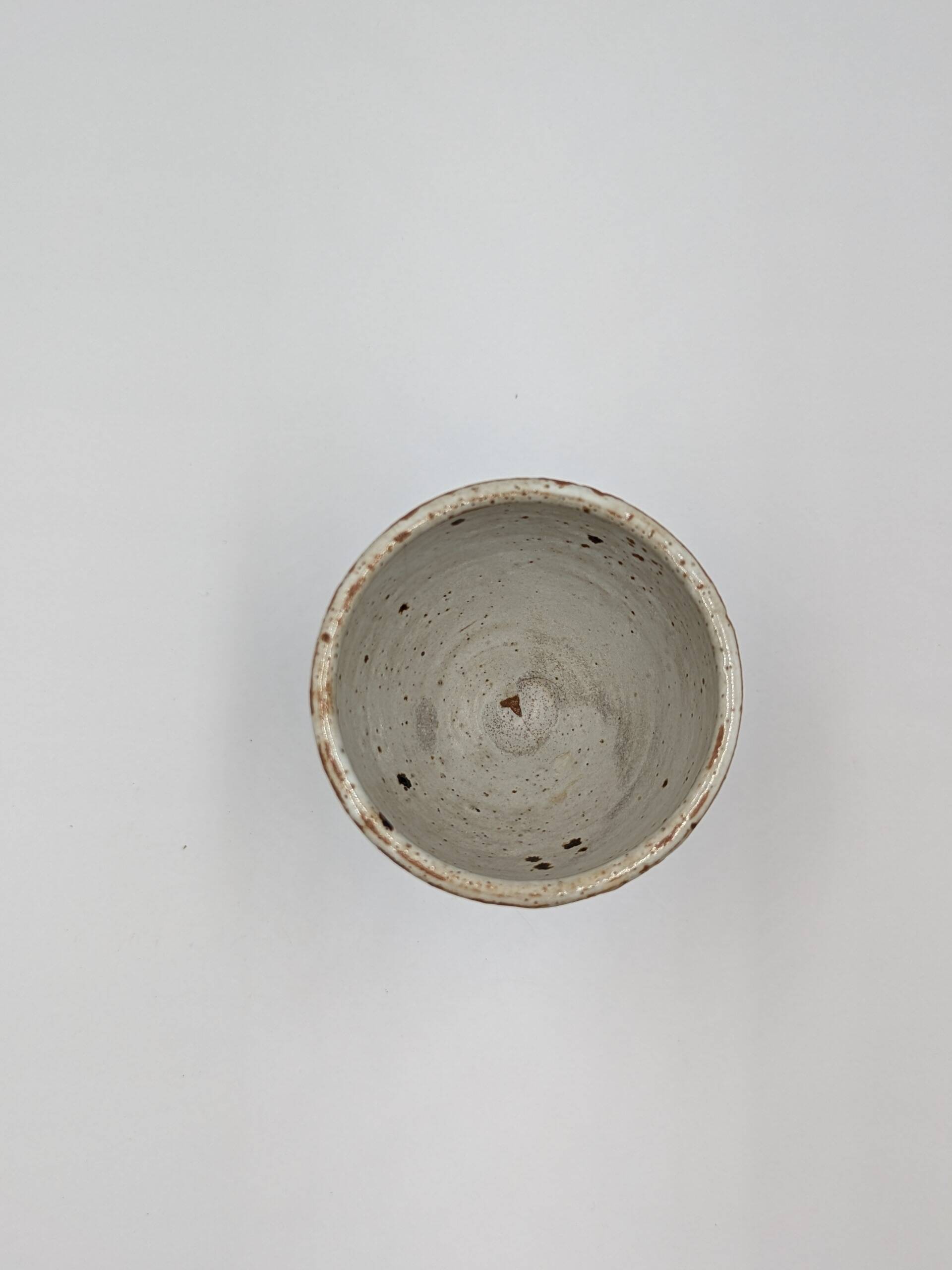 Glass on foot in pearly white stoneware with black spots