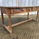 Old chestnut table with 3 front drawers and a cat bar.