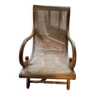 Colonial-style wooden and cane armchair