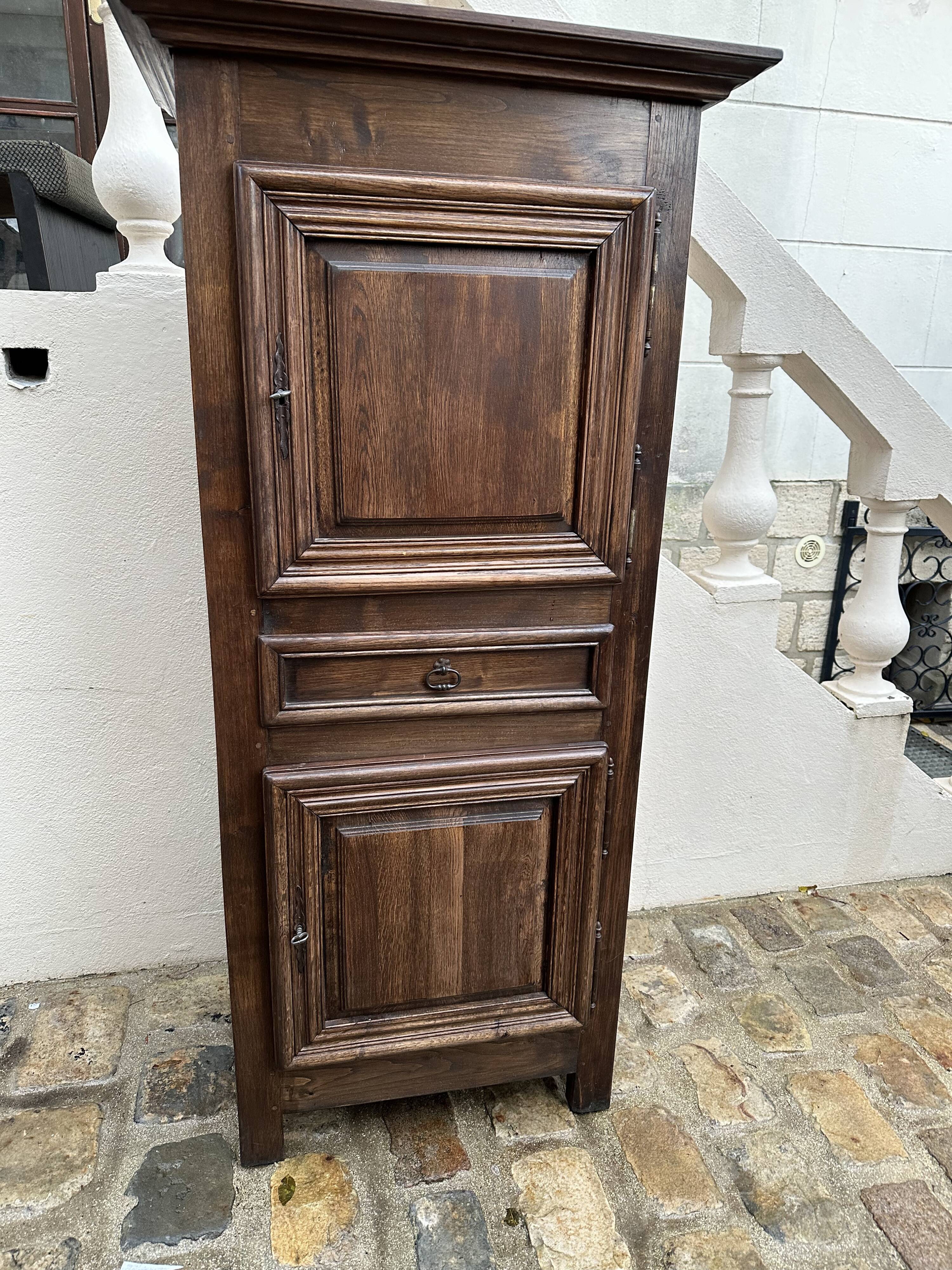 Homme debout armoire étroite à deux portes avec un tiroir central