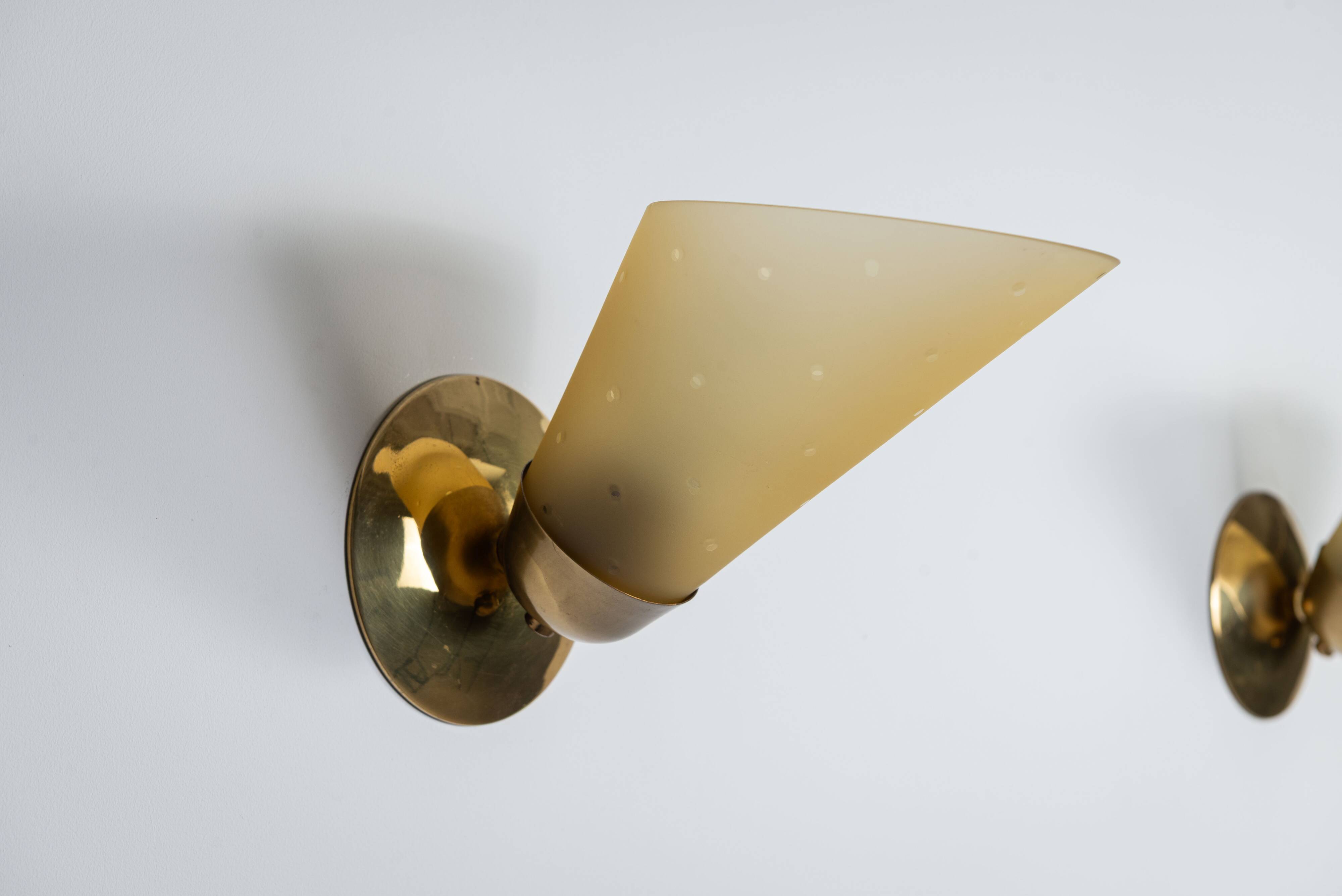 Set of three brass sconces with decorated yellow glass shades