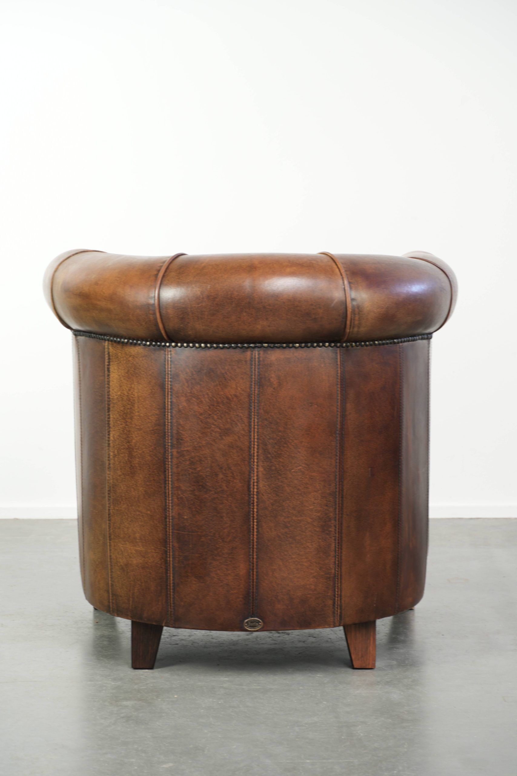 Sheepskin clubarmchair with beautiful patina finished with decorative nails