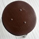 Dark brown metal stool, minimalist three-legged design