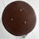 Dark brown metal stool, minimalist three-legged design