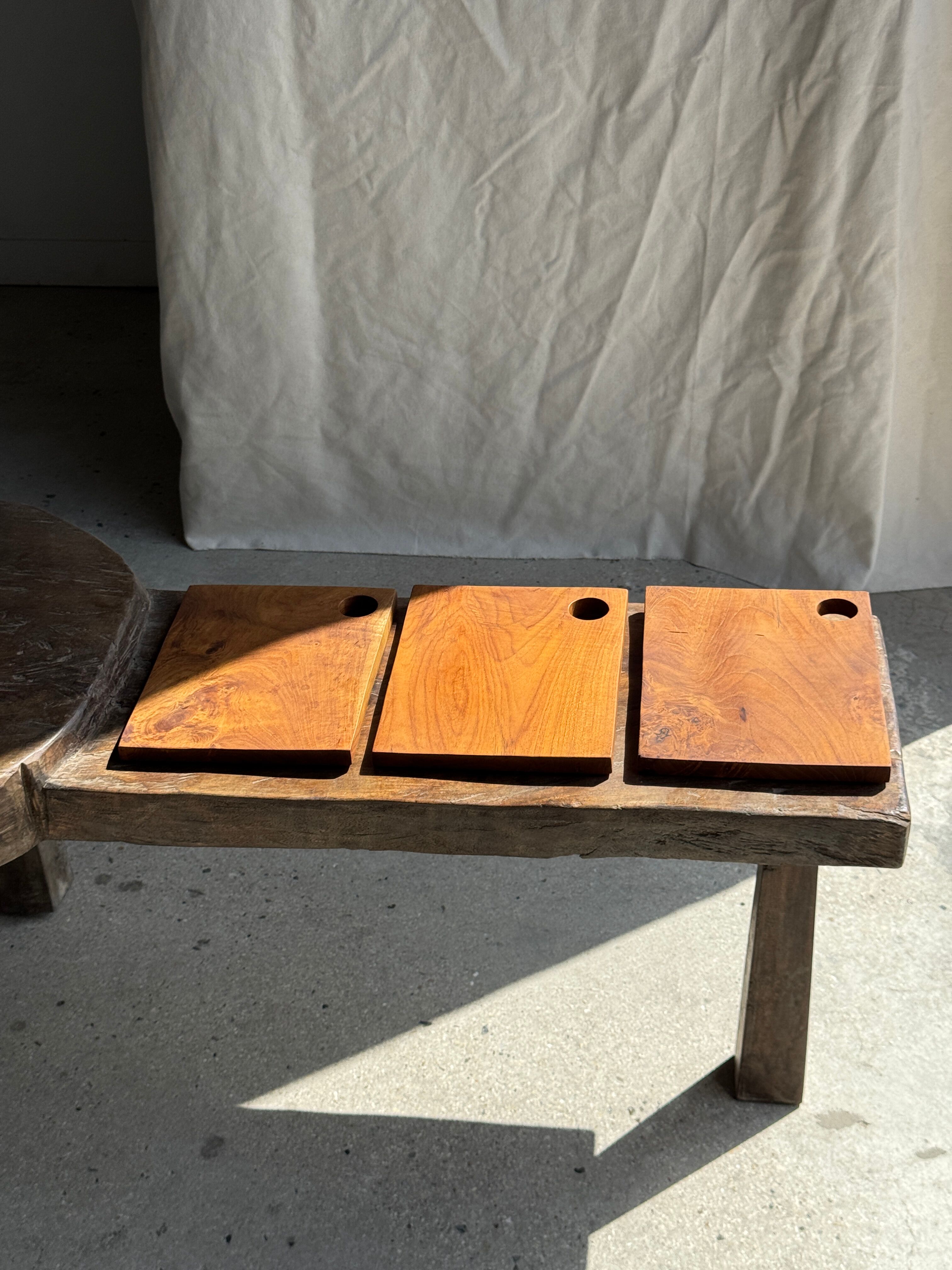 Small rectangular teak monoxyle cutting board with a circular handle.