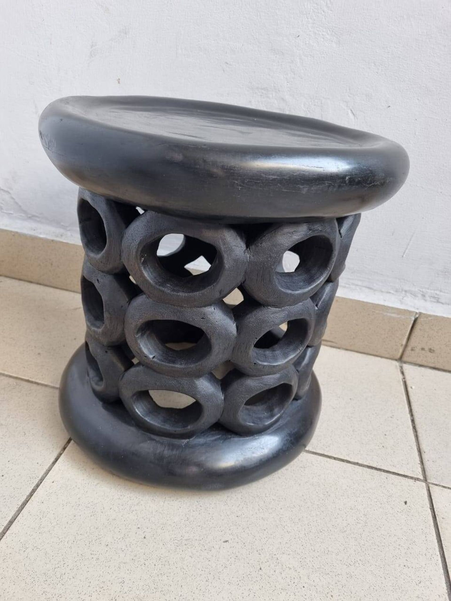 Bamiléké black stool in carved wood with rings – 33 × 35 cm