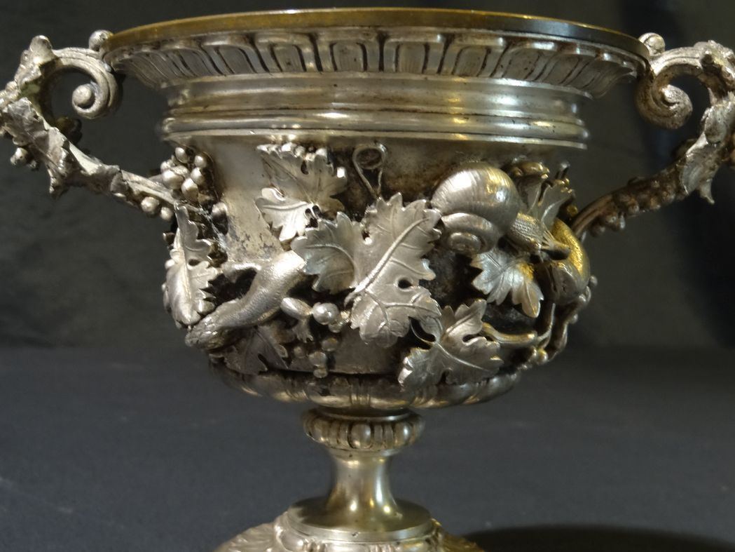 Carved silver bronze vase mounted on marble pedestal