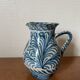 Blue ceramic pitcher with floral patterns