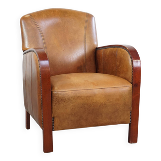 Sheepskin Art Deco design armchair with wooden armrests and a fixed seat cushion