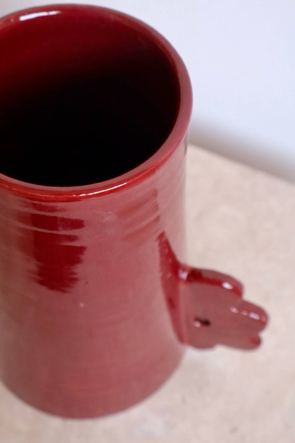 Handmade abstract ceramic vase with asymmetrical handles and burgundy flower