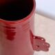 Handmade abstract ceramic vase with asymmetrical handles and burgundy flower