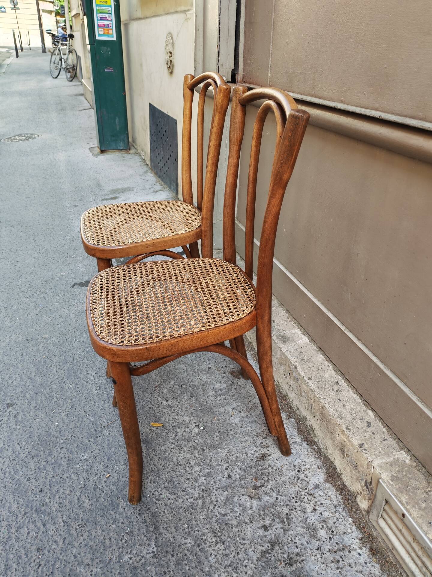 Pair of vintage bistro chairs in curved wood and caning.