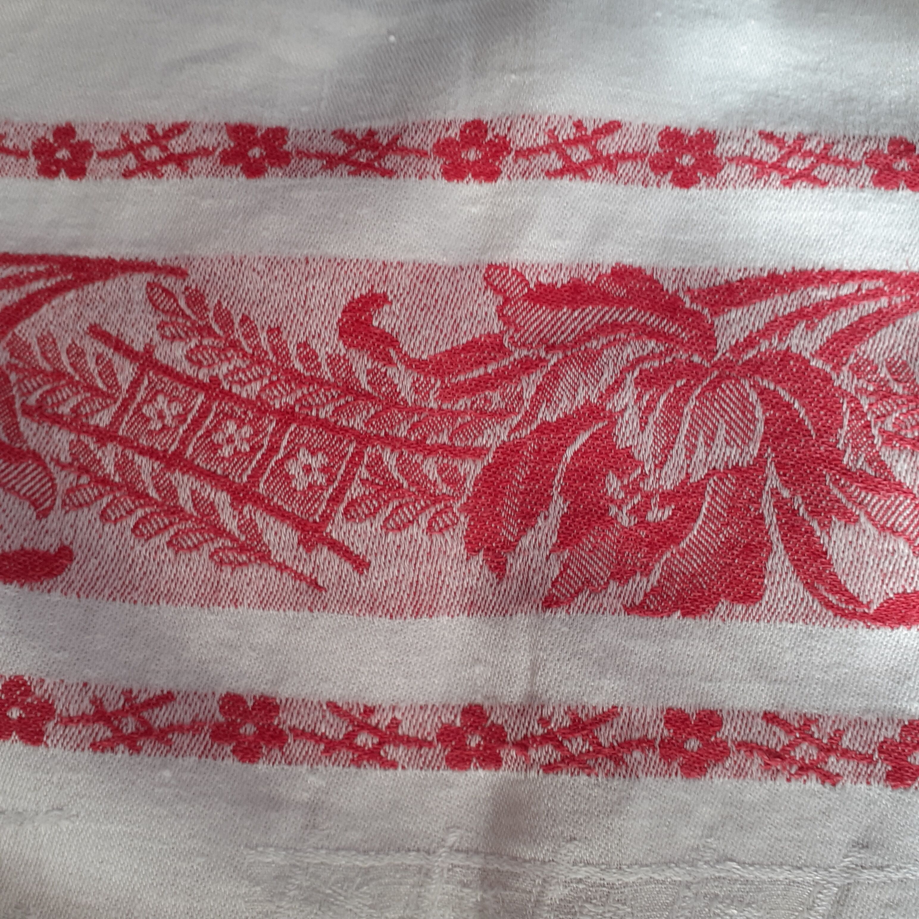 Ancient damask tablecloth. Surroundings borders red. Red central monogram.