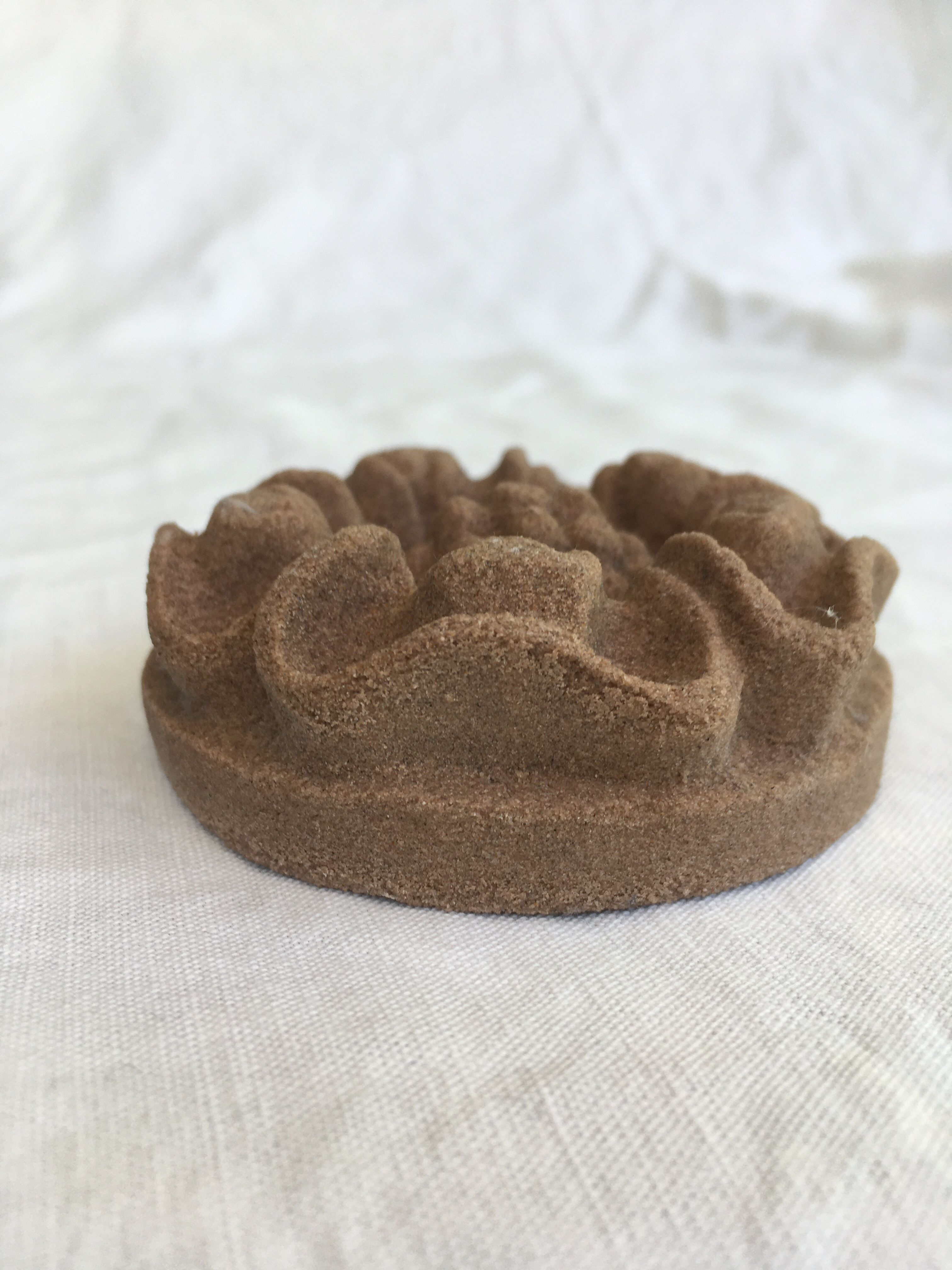 Pink sandstone paperweight in the shape of a rosette