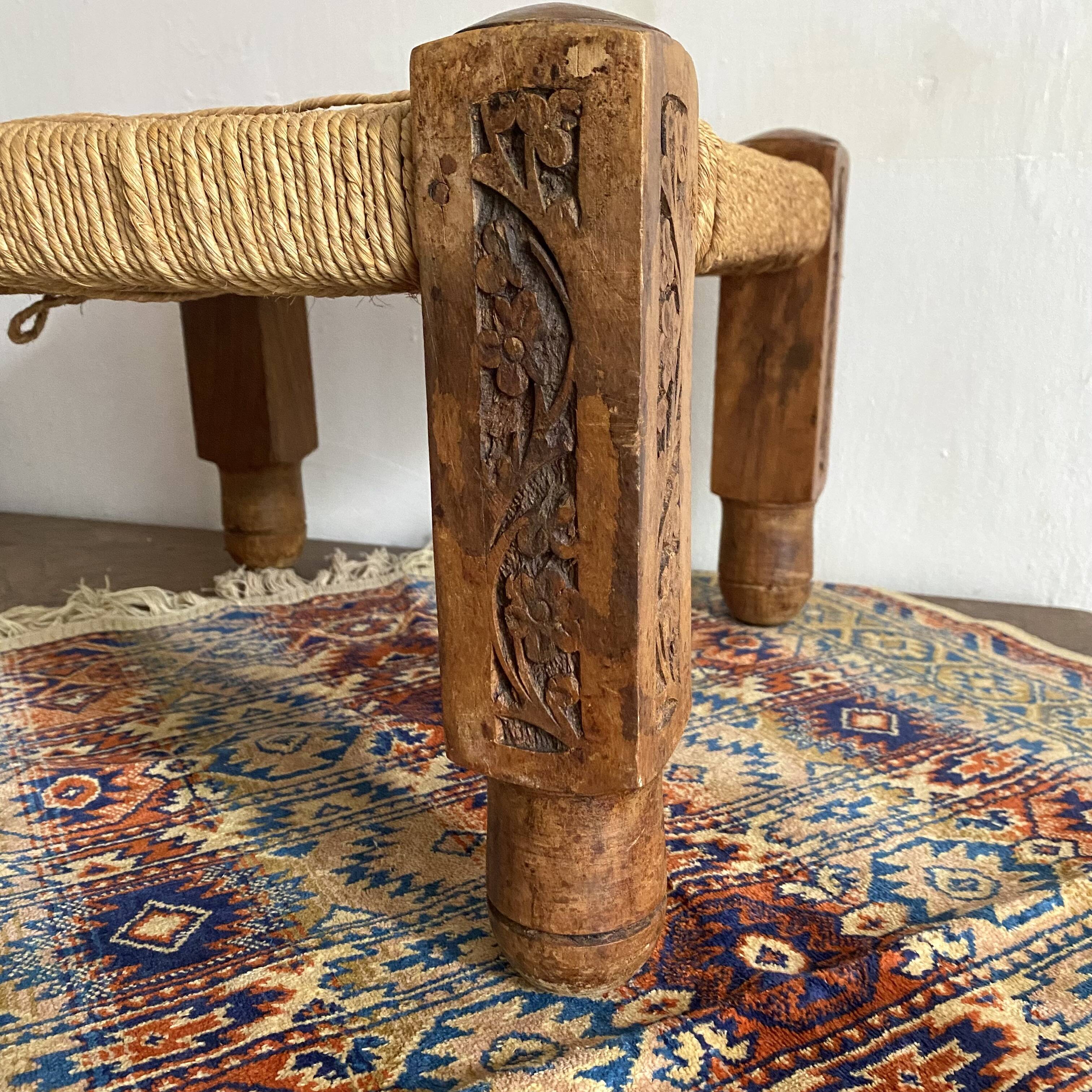 Low stool with carved wood and braided cord.