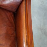 Comfortable Art Deco design armchair in cognac-colored sheepskin combined with wood