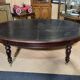 Large English library table in dark walnut with a leather top.
