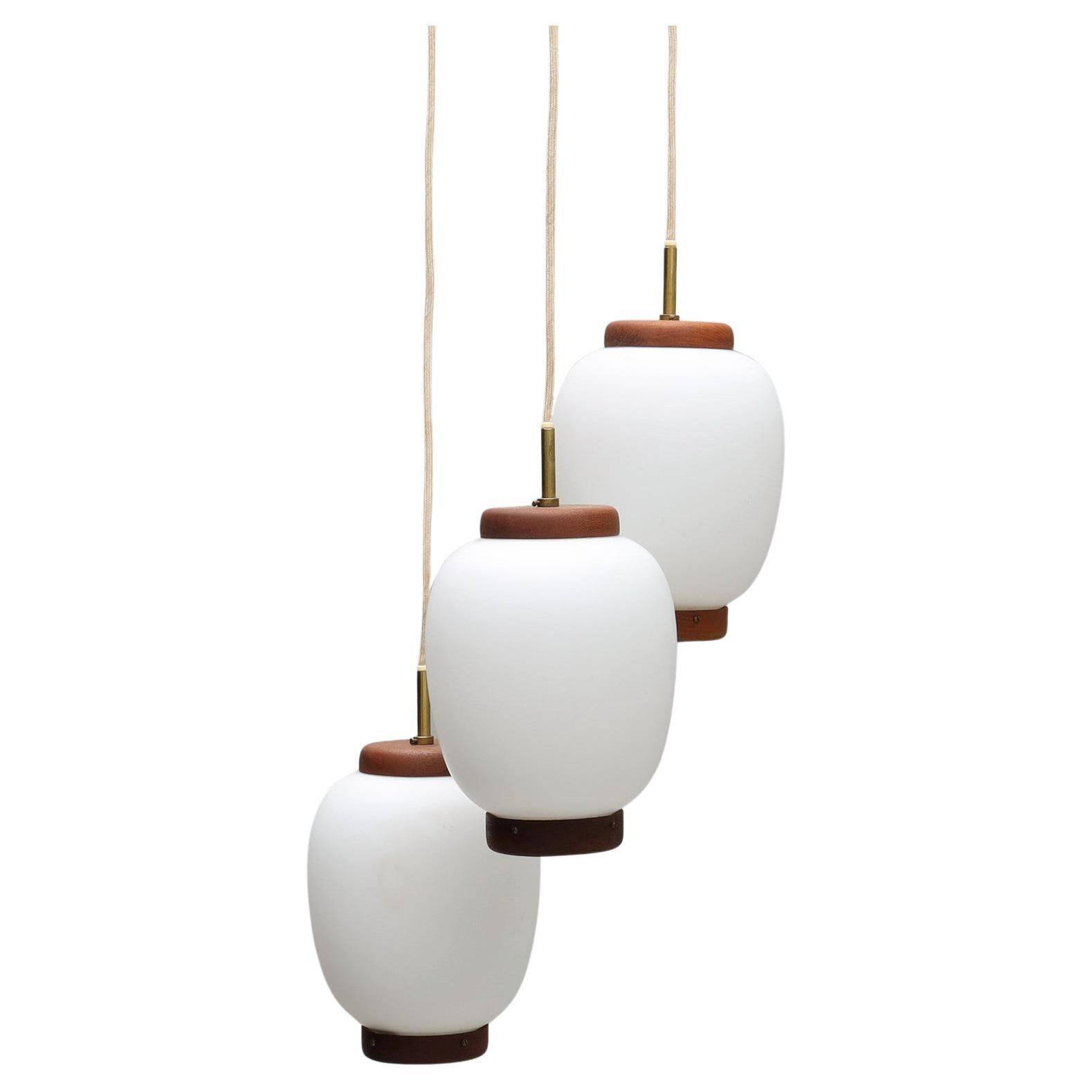 Bent Karlby "China" pendant lights, 3 lights, teak and glass, Lyfa, Denmark, 1960.