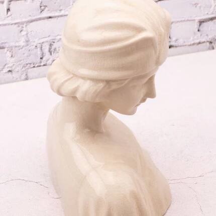 Bust of a young woman in cracked white porcelain.