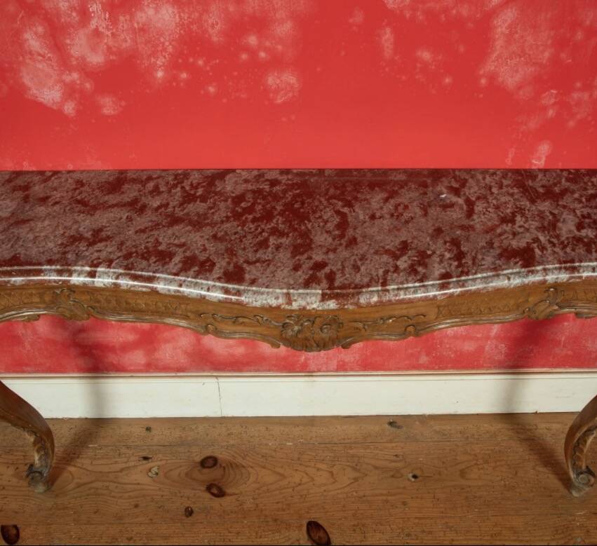 Important console in natural wood, moulded and carved with a red marble top.