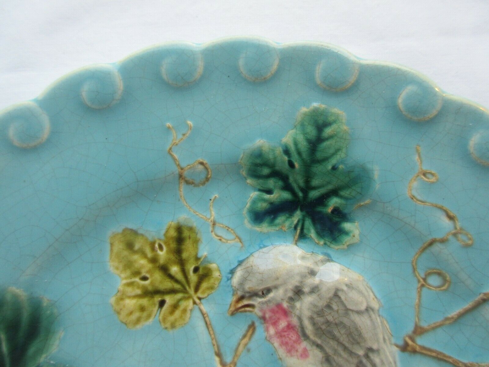 Blue barbotine plate of Sarreguemines: Birds pecking at yellow grapes