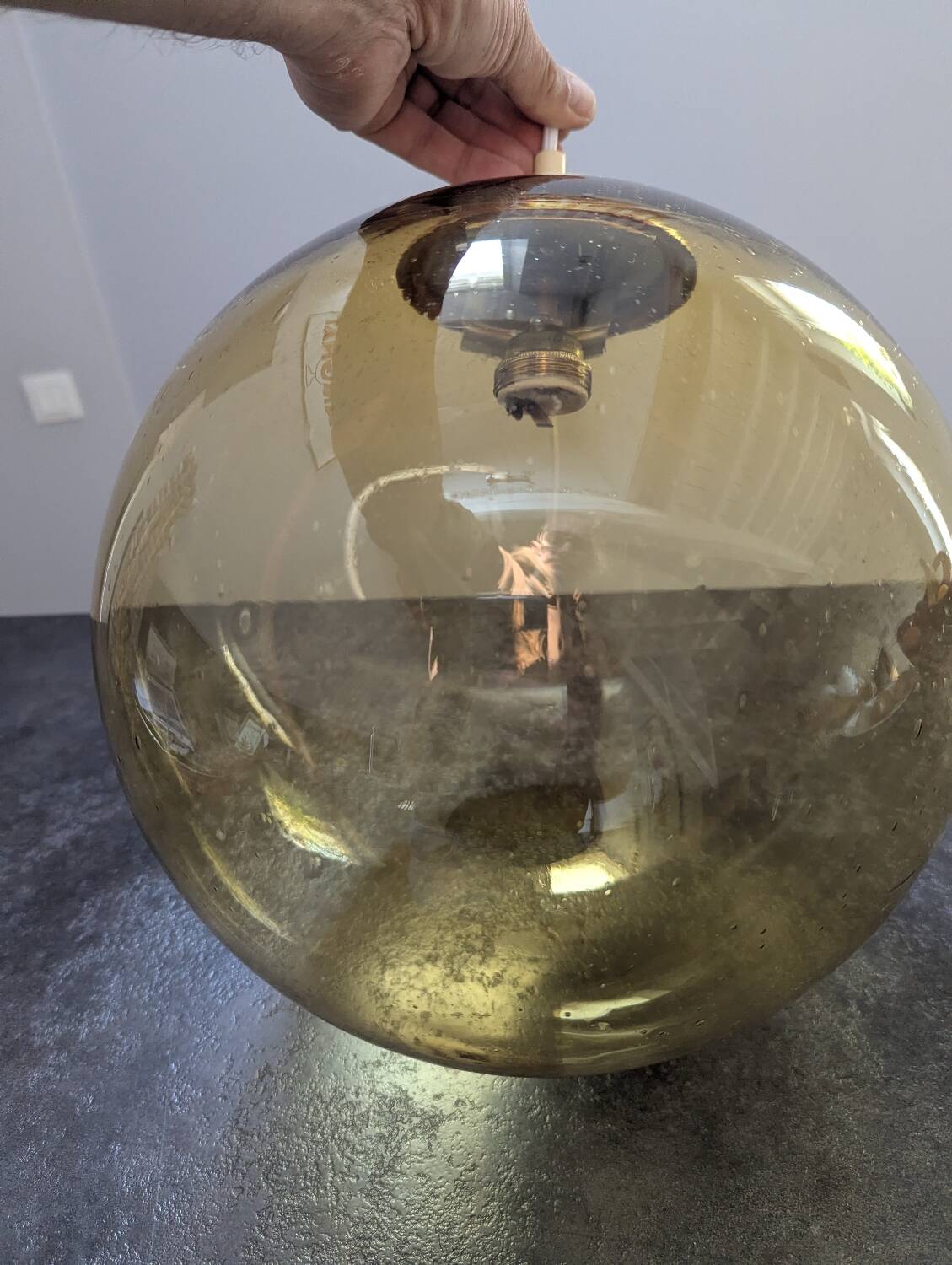 Old large and imposing thick glass globe with a bubbled amber colour, vintage.
