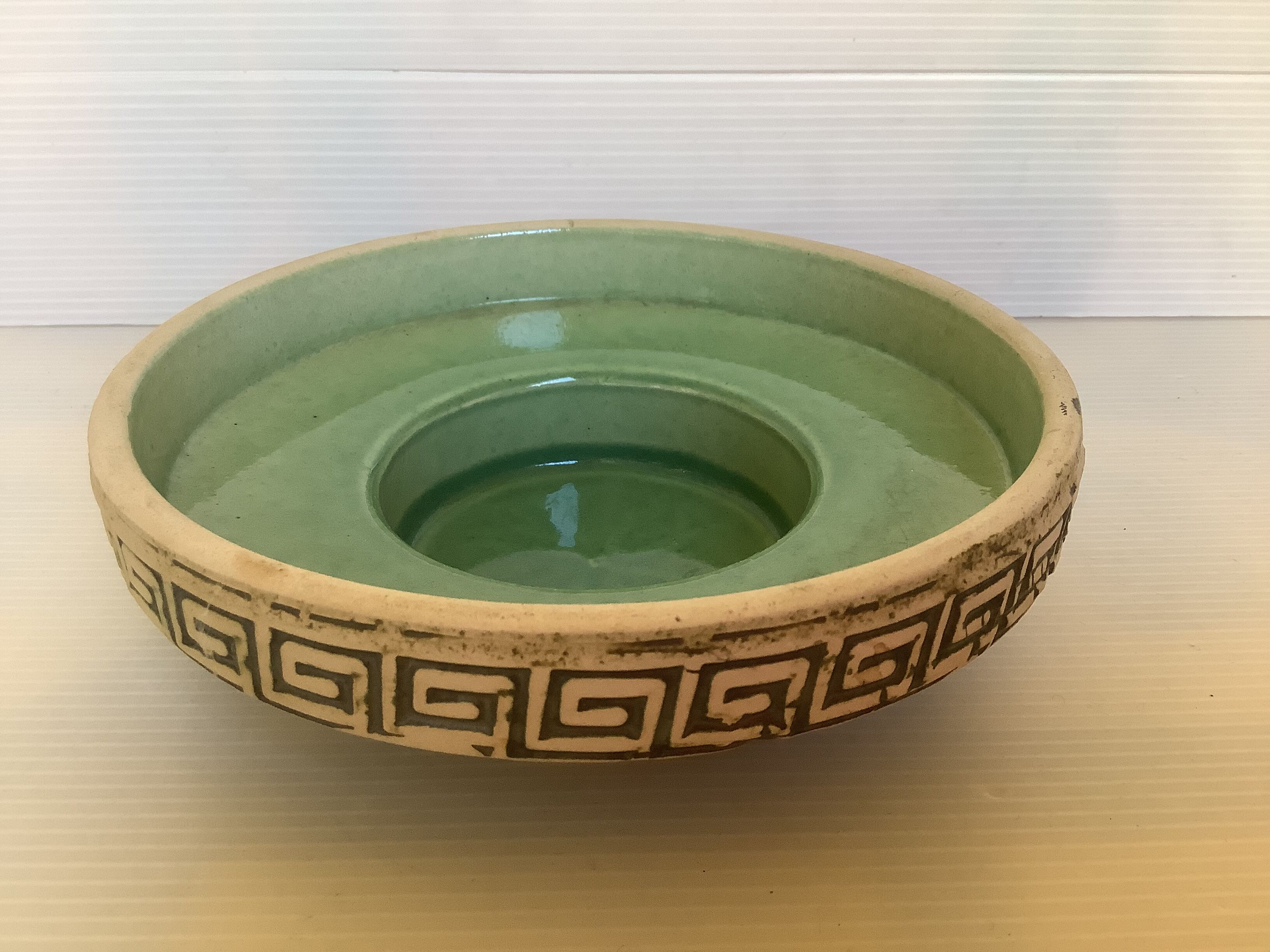 Green ceramic candle holder with a frieze